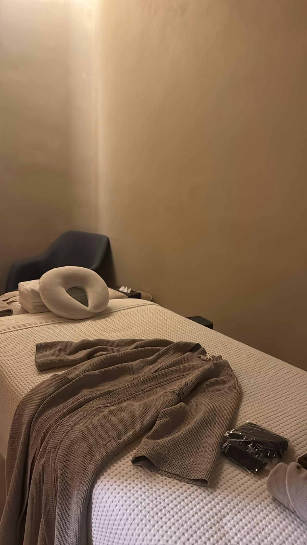 Massage table prepared with a fresh sheet, face cradle, robe and slippers at Andrea Massage and Spa in Little Neck
